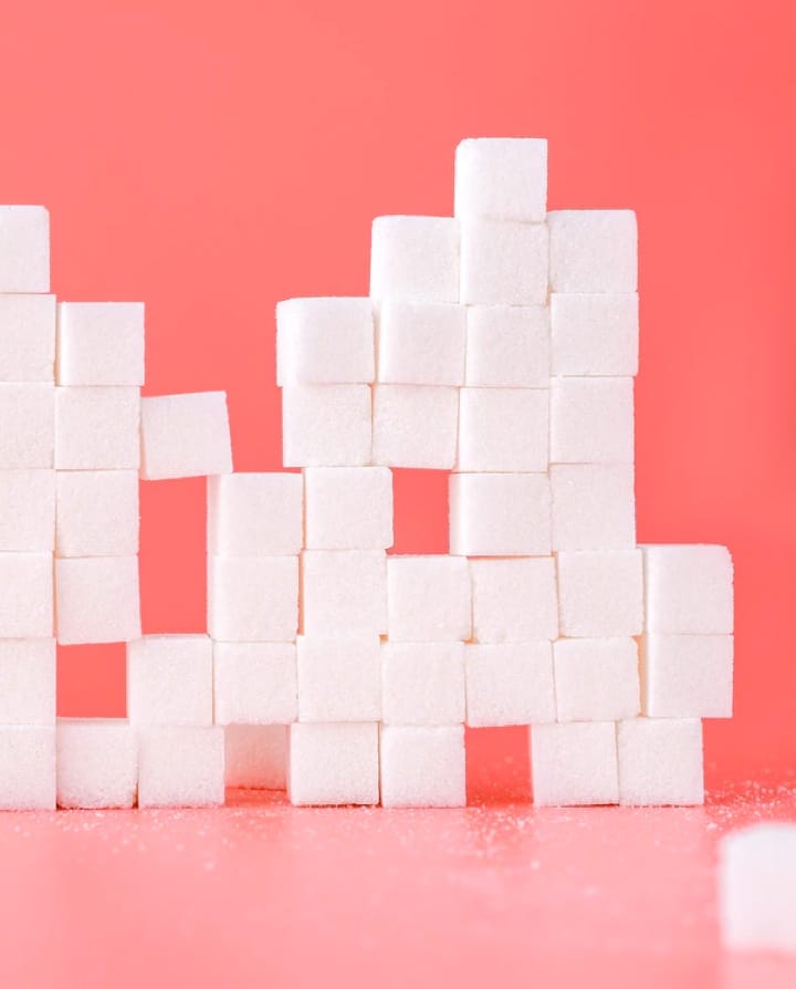 Image of sugar cubes on a salmon background.